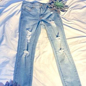 Light wash blue denim jeans with rips